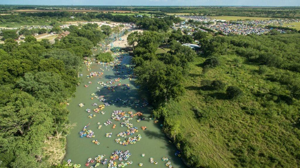 Drone shot of hundreds of rafters floating down a river.