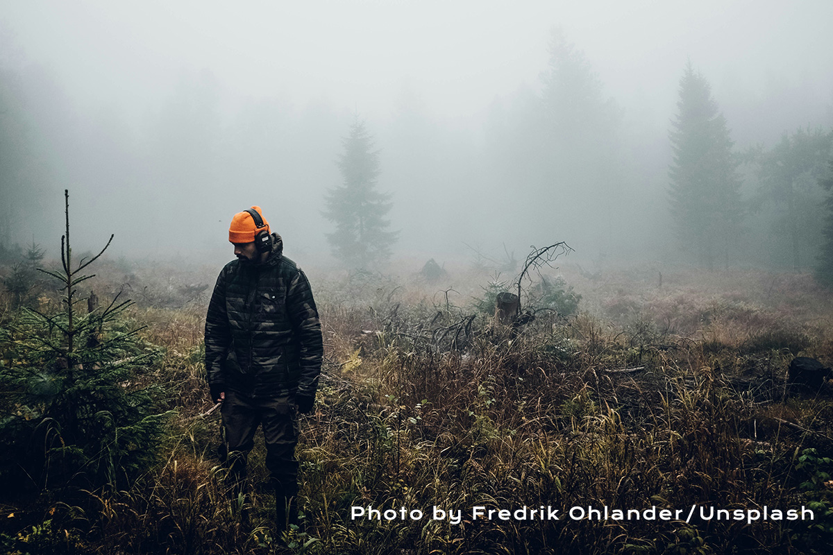 hunter standing in the woods
