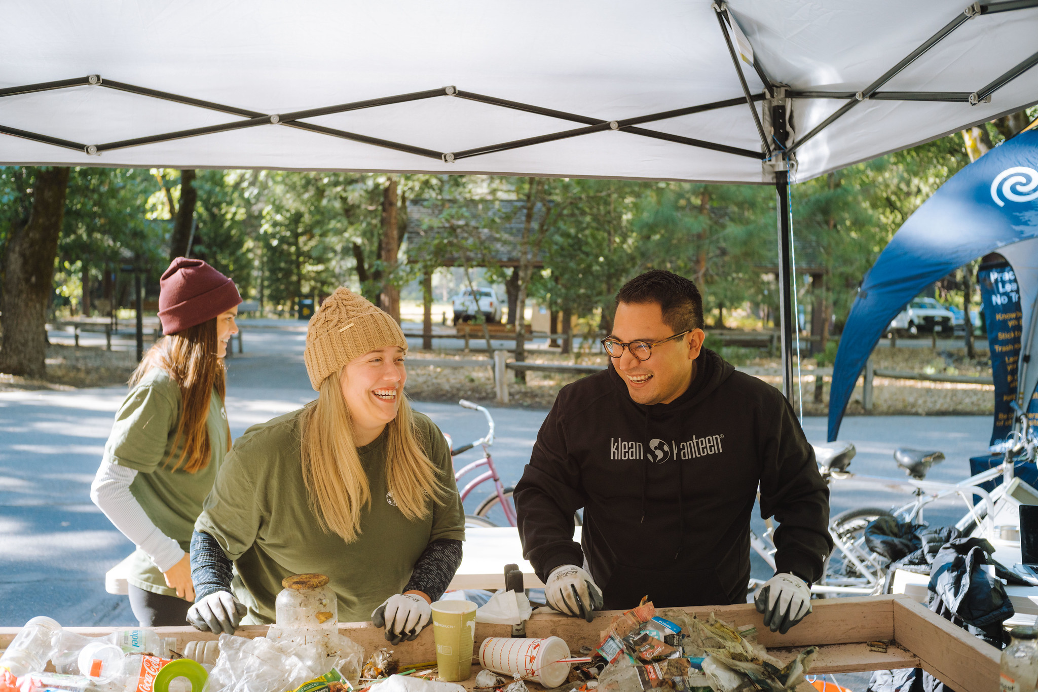 Two people sort recyclables from trash.