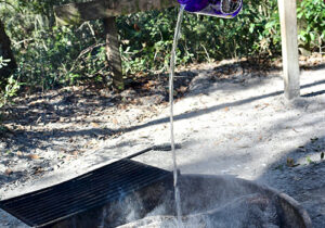 a stream of water being poured on a campfire