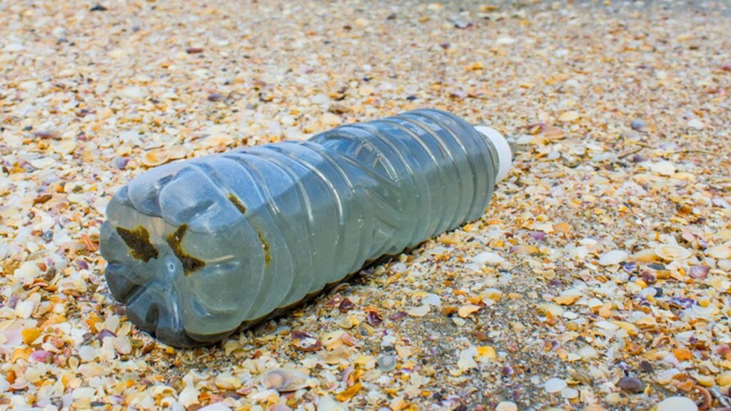 Plastic water bottle laying on sand